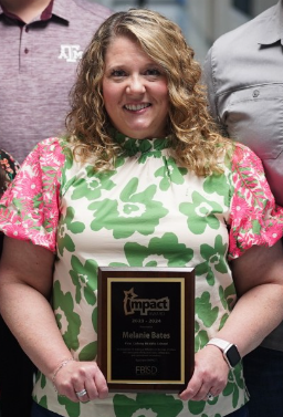 Kim Davis holding the Impact Award plaque